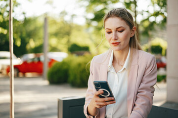 Close up of a businesswoman using smartphone outdoors in the city