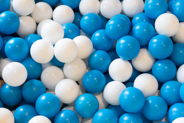 white and blue plastic balls background and texture. balls in kid indoor playground.