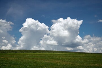 Fototapeta na wymiar a large green field with clouds in the sky, Bavaria, Germany