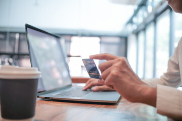 Woman holding credit card and using laptop computer. Online shopping concept.