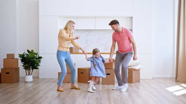 Amazed family parents and preschooler daughter dance in flat