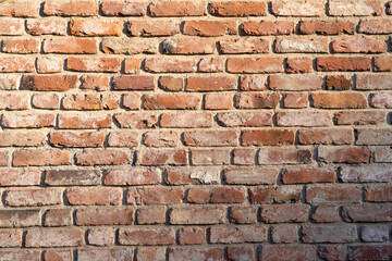 New brickwork made from old, previously used red bricks. There are chips, cracks and remnants of old plaster. Each brick is different. Background. Texture.