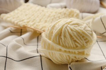Knitting yarn and needles on fabric background, closeup