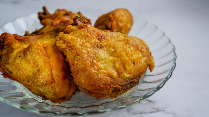 Ayam Goreng Kunyit isolated with marble background. Selective focus.