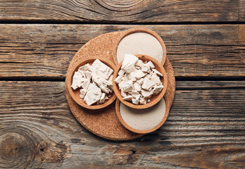 Board with fresh and dry yeast on wooden background
