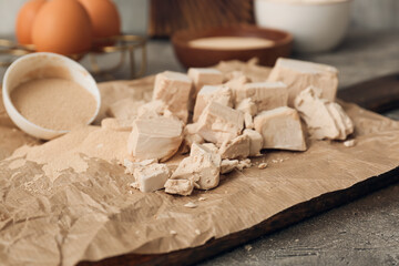 Wooden board with fresh and dry yeast on grunge background