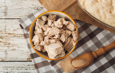 Composition with fresh and dry yeast on light wooden background
