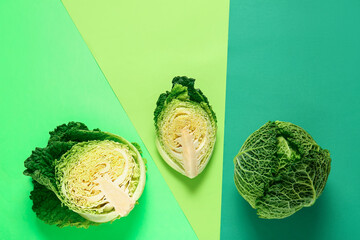 Pieces of fresh savoy cabbage on color background