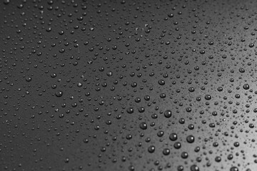 drops of water on a black background. dew on the surface.