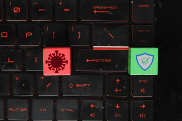 Red wooden block symbol as virus and threat. Green wooden block as security on laptop keayboard