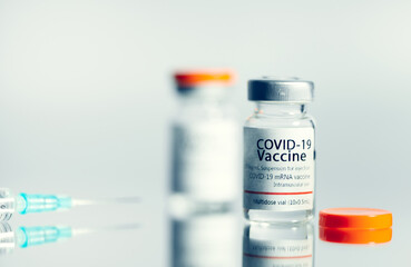 Ampoules with COVID-19 coronavirus vaccine, with a syringe for vaccination. Healthcare And Medical concept.