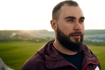 Fototapeta premium Young bearded man portrait outdoors in the mountains