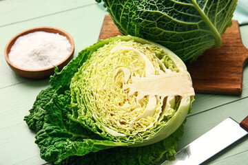 Board fresh savoy cabbage on color wooden background, closeup