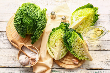 Board with pieces of fresh savoy cabbage on light wooden background