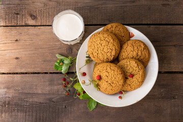 Cookies and milk with strawberry on wooden table with green background. recreation consept in the village