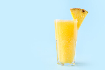 Glass of tasty pineapple smoothie on color background