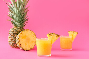 Glasses of tasty pineapple smoothie on color background