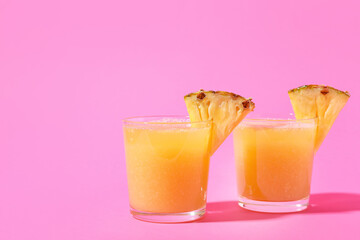 Glasses of tasty pineapple smoothie on color background