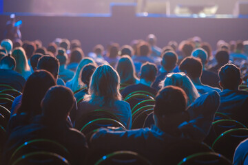 Unrecognizable people sitting in dark auditorium