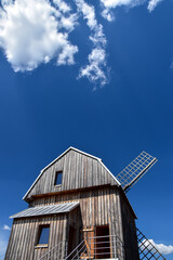 Old, wooden windmill seen from below against blue sky