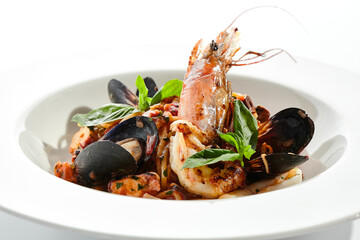 Seafood spaghetti pasta - spaghetti plate with seafood mix. Pasta dish with shrimp, mussel and octopus. Restaurant gourmet seafood and pasta food plate isolated on white background..