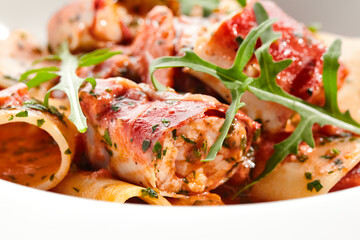 Tuna Cannelloni pasta - noodles plate with tuna fish meat. Pasta dish with tuna, tomato sauce and rocket salad. Restaurant gourmet cannelloni pasta food plate isolated on white background..