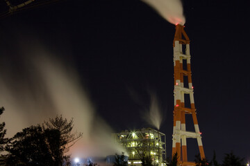 ライトアップされた夜の工場の煙