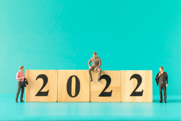 Miniature people : Business people standing on wooden block number 2022 , Happy new year concept