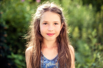 Naklejka premium Portrait of a beautiful smiling girl on a sunny day in nature