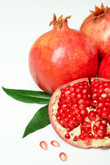 Ripe pomegranate with leaves on white background