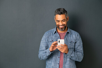 Mature indian man messaging on smartphone - Powered by Adobe
