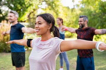 Mixed race woman exercising in park with mature friends - Powered by Adobe