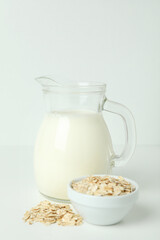 Pitcher of milk and cereals on white background