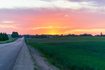 Fototapeta na wymiar Beautiful rural asphalt road scenery at sunset.Asphalt Road between fields trees.beautiful summer landscape road sunset.