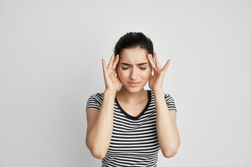 woman with unhappy facial expression holding her head migraine pain