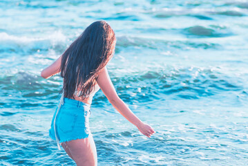 Young woman playing in the sea.woman enjoying in sea water .Cheerful young woman having fun on the summer beach.