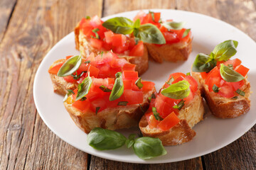 plate of bruschettas with tomato and basil