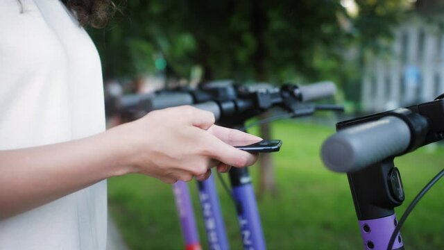 Person rents electric scooter using mobile phone app