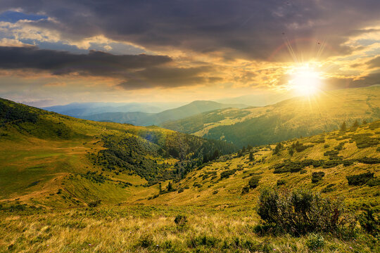 carpathian mountain landscape at sunset. beatiful scenery with green rolling hills in evening light beneath a dramatic sky with clouds in summer. explore backcountry concept