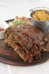 Grilled and smoked ribs with barbeque sauce on a carving board