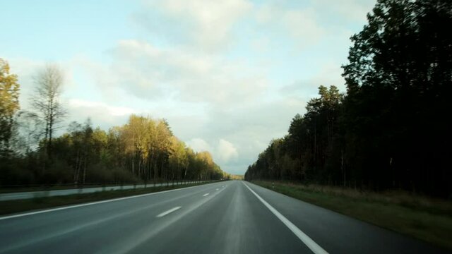 Driving on a highway with traffic from cars. Autumn cloudy weather, background