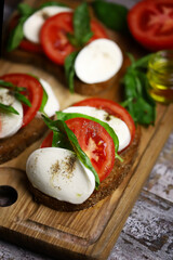 Caprese toast on a wooden board. Italian mood dish.