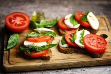 Caprese toast on a wooden board. Italian mood dish.