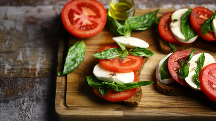 Caprese toast on a wooden board. Italian mood dish.