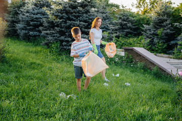 A group of girls with children at sunset are engaged in garbage collection in the park....
