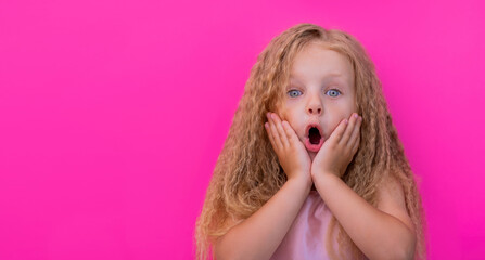 surprise portrait of amazed little girl with open mouth wow on pink background advertising for kids...