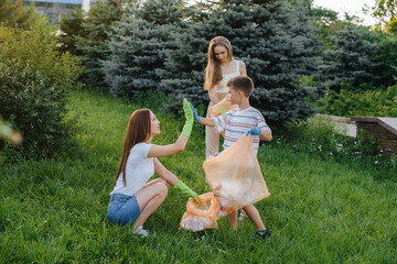 A group of girls with children at sunset are engaged in garbage collection in the park....