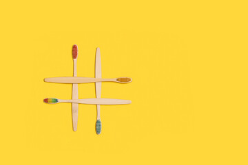 Cepillos de dientes ecológicos de bambú sobre un fondo amarillo liso y aislado. Vista superior. Copy space