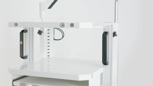 Close up of a white cabinet for a medical laboratory on white wall background. Video. New furniture for a medical office.