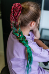 Colored braids on an elastic band on a teenage girl